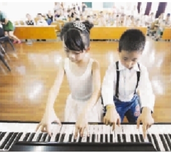 美国版数字报-与农民工孩子一同弹钢琴